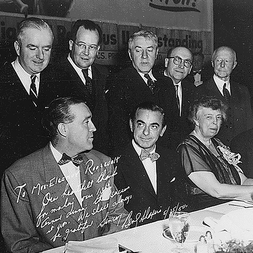 Singer Eddie Cantor (center) sits next to former First Lady Eleanor Roosevelt at a dinner of the Massachusetts Committee of Catholics, Protestants, and Jews in Boston, MA, May 25, 1950. Also seated (left to right): Frank Leahy and Paul Devers.