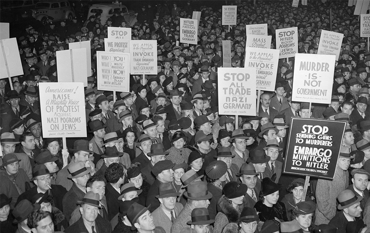 Americans protesting Nazi Germany carrying signs.